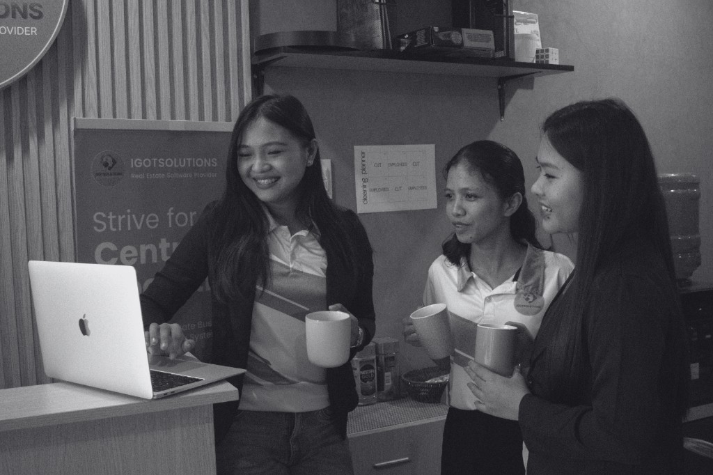 The iGotSolutions team collaborating around a laptop in their Cebu office